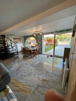 a living room with a table and a patio at Villa moderne 3 chambres double , proche de la mer, le Micocoulier quartier sainte Marguerite in La Garde