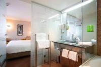 a bathroom with a shower and a sink and a bed at Hotel Lille Euralille - Hilton Affiliate Hotel in Lille
