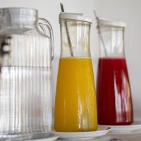 アチンスにあるSanta Maria Atinsのケチャップのピッチャーの横にオレンジジュースの入ったガラスの瓶