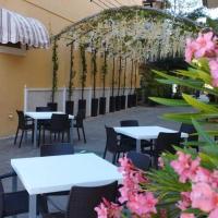 d'une terrasse avec des tables, des chaises et des fleurs blanches. dans l'établissement Cancun International Suites, à Cancún