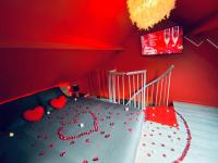 a red bedroom with a bed with hearts on it at La Valentine Spa in Béthisy-Saint-Pierre