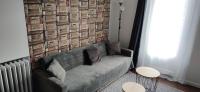 a living room with a couch and a brick wall at Relais De La Tour in Callac