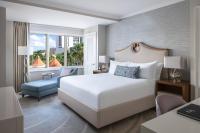 a bedroom with a white bed and a blue chair at The Ritz-Carlton, Sarasota in Sarasota