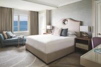 a bedroom with a large white bed and a chair at The Ritz-Carlton, Sarasota in Sarasota