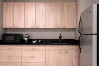 a kitchen with wooden cabinets and a stainless steel refrigerator at The Ritz-Carlton, Sarasota in Sarasota