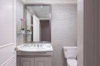 a bathroom with a sink and a mirror and a toilet at The Ritz-Carlton, Sarasota in Sarasota