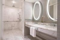 a white bathroom with a sink and a shower at The Ritz-Carlton, Sarasota in Sarasota