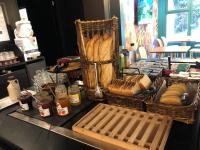 a table with baskets of bread and other food at KYRIAD HONFLEUR - La Riviere Saint Sauveur in Honfleur