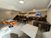 Un restaurante con mesas y sillas y un bar. en I Live Motel, en Kaohsiung