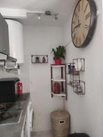 a clock hanging on a wall in a kitchen at Charmant appartement à Sainte Marie la mer (66470) in Sainte-Marie-Plage