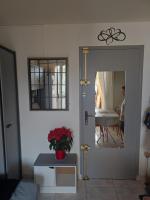 a living room with a mirror and a table with a plant at Charmant appartement à Sainte Marie la mer (66470) in Sainte-Marie-Plage