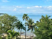 een uitzicht op een strand met palmbomen en de oceaan bij Kooncharaburi Resort - Koh Chang in Ko Chang