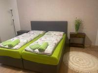 a green bed with two green pillows on it at Apartment am Schlosspark 3 in Cheb