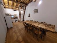 a dining room with a table and chairs and a refrigerator at Gîte de la Ferme de la Comté in Le Thillot