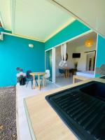 una sala de estar con una pared azul y una mesa en HAMACA 107 KAWANN CENTER, en Grand-Bourg