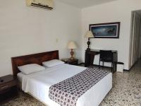 Un dormitorio con una cama grande y un escritorio. en Hotel Estación by Destino Pacifico, en Buenaventura