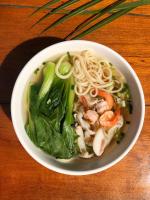 uma tigela de sopa com macarrão de camarão e verduras em Ecran Riverfront Guesthouse em Kampot