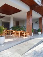 un patio al aire libre con mesas y sillas de madera en Mesari Villa, en Keramas