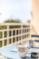 a table with two cups and saucers on it at Superbe studio avec balcon vue mer&#47;climatisation in Cagnes-sur-Mer
