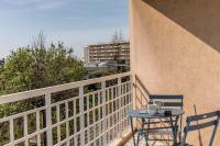 a table and chairs on a balcony with a building at Superbe studio avec balcon vue mer&#47;climatisation in Cagnes-sur-Mer