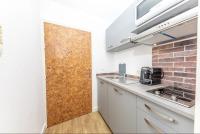 a kitchen with a wooden door in a room at Superbe studio avec balcon vue mer&#47;climatisation in Cagnes-sur-Mer