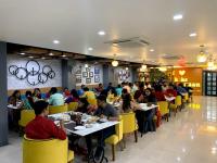 un grupo de personas sentadas en mesas en un restaurante en Hotel Raas Inn, New Hotel, en Udaipur