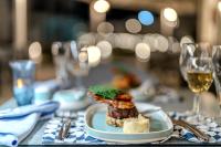 a plate of food on a table with wine glasses at Casa Blue Resort in Marsa Alam City