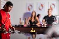 a man in a kitchen with a fire in a bowl at Casa Blue Resort in Marsa Alam City