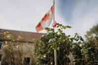 a canadian flag flying in front of a building at Les Granges Pelloquin in Bernières-sur-Mer