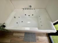 a white bath tub sitting inside of a room at Maputo - Appartement climatisé in Reims