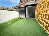 a garden with a green lawn next to a building at Maputo - Appartement climatisé in Reims