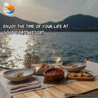 ein Tisch mit Tellern mit Essen und Gläsern Wein in der Unterkunft Gold Coast Beach Resort, Kund Malir in Kund Malīr