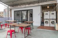 a room with tables and chairs and washing machines at Light Hostel in Chiayi City