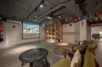 a room with a projection screen and a table and chairs at Light Hostel in Chiayi City
