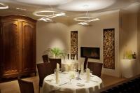 uma sala de jantar com uma mesa com toalha de mesa branca e cadeiras em Hotel Weiherhof am Golfpark em Wadern