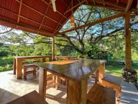 a wooden table and chairs on a patio at Tayrona Cachaco River Ecohostal in El Zaino