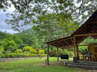 a pavilion in a park with a mountain in the background at Tayrona Cachaco River Ecohostal in El Zaino