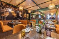 a restaurant with tables and chairs and a large mural at Studio 42 with kitchenette at the new Olo living in Paceville
