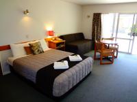 Una habitación de hotel con una cama y una sala de estar. en Aalton Motel, en Christchurch