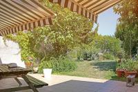a patio with a wooden umbrella and a garden at Chambres d&#39;Hôtes Villa Bellevue in Albi