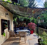 a patio with a table and chairs under a pergola at La Maison Thébaïde in Mortagne