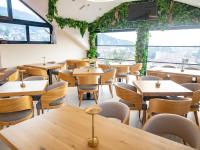 a restaurant with tables and chairs and a large window at Hotel Herc Sarajevo in Sarajevo
