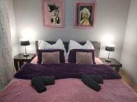 1 dormitorio con 1 cama grande con manta morada en Skitnica Marilyn, en Koprivnica