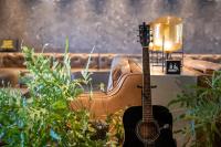 a guitar sitting in a room with plants at The Millennials Kyoto in Kyoto