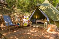 a tent with a bed and chairs on a wooden deck at Camping U Pirellu in Porto-Vecchio