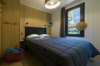 a bedroom with a blue bed and a window at Camping U Pirellu in Porto-Vecchio
