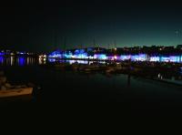 a marina at night with blue and purple lights at château de Locquéran Pierres et filets bleus in Plouhinec