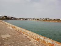 a view of a body of water next to a sidewalk at château de Locquéran Pierres et filets bleus in Plouhinec