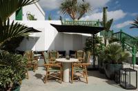 a patio with chairs and a table and umbrella at César Lanzarote Luxury Boutique Hotel - Adults Only in La Asomada