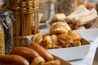 a table with two boxes of pastries and a basket of bread at Residence Inn by Marriott Paris Didot Montparnasse in Paris